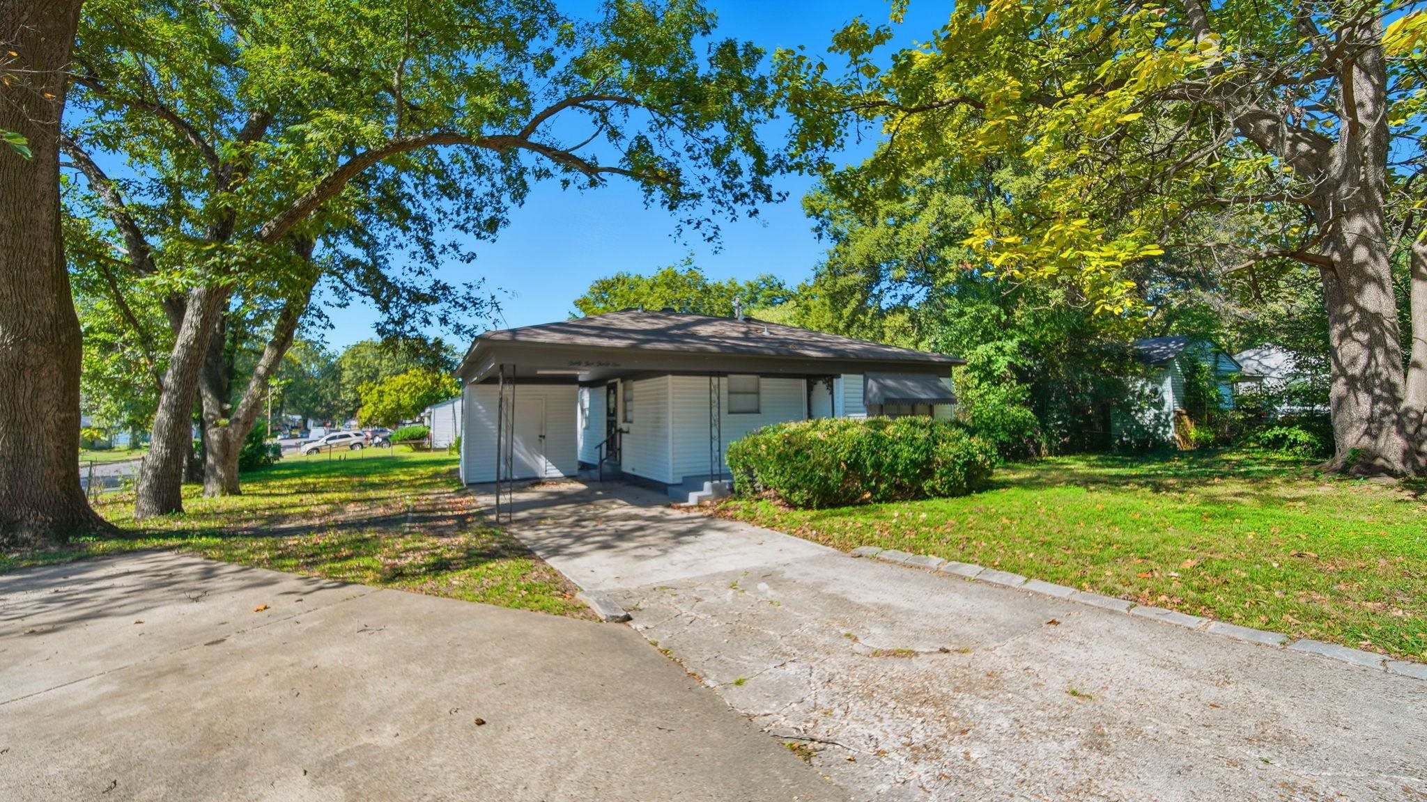 3531 Randolph Street Memphis, TN 38127 - Photo 3 of 32 a front view of a house with a garden and trees