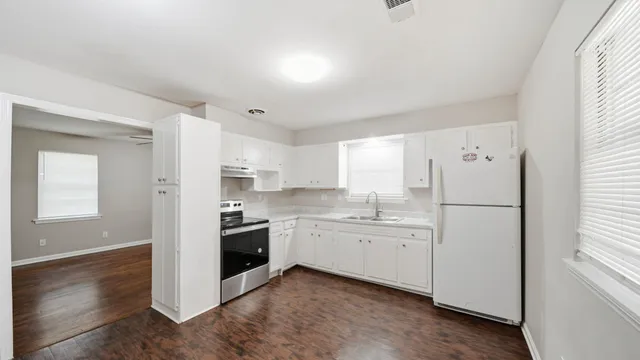 a kitchen with white cabinets and white appliances
