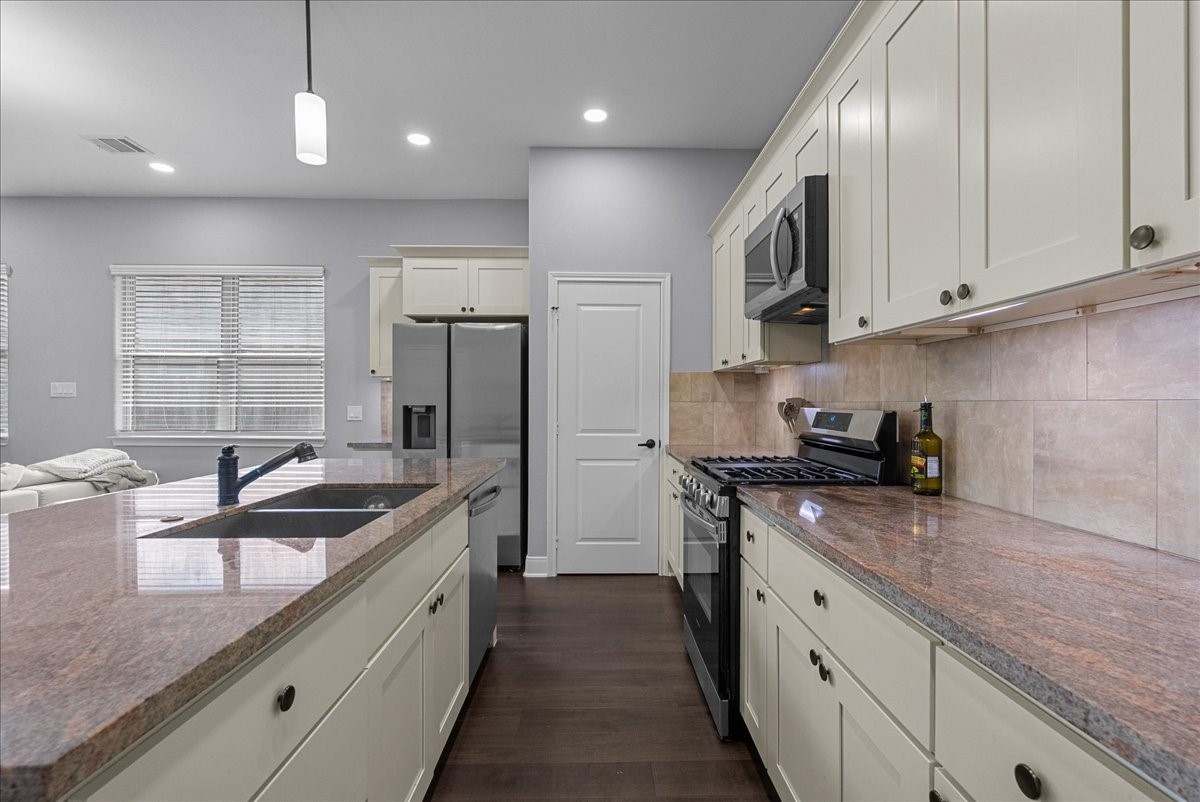 20061 Torrey Pines Lane Cleveland, TX 77327 - Photo 15 of 41 a kitchen with stainless steel appliances granite countertop a sink a stove and a refrigerator