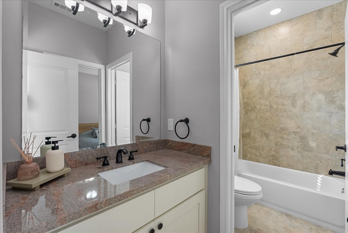 20061 Torrey Pines Lane Cleveland, TX 77327 - Photo 22 of 41 a bathroom with a granite countertop sink a toilet and bathtub