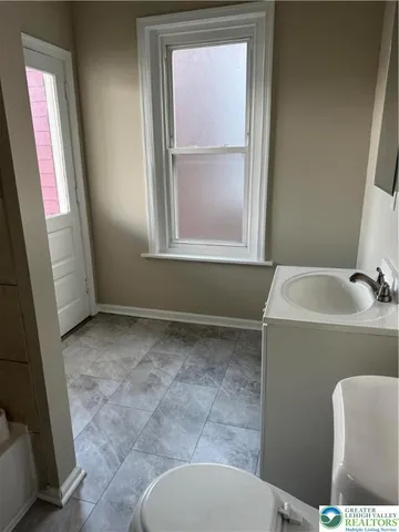 a bathroom with a toilet sink and mirror