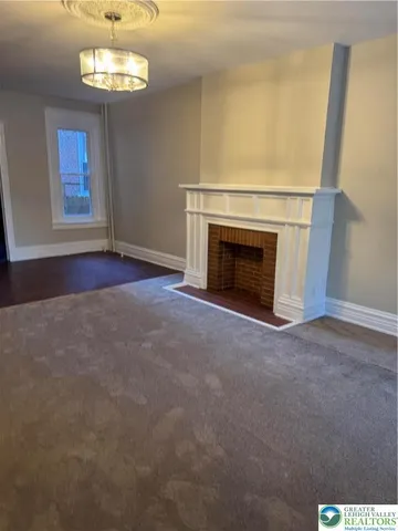 an empty room with windows cabinet and fireplace