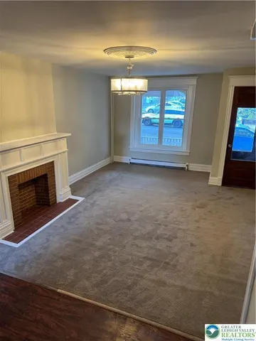 a view of empty room with window and fireplace