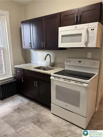 a kitchen with stainless steel appliances granite countertop a sink and a microwave