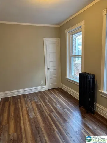 a view of room with window and wooden floor