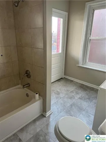 a bath room with a toilet and a bath tub