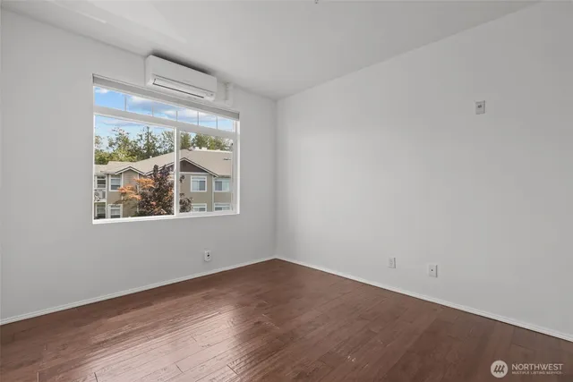 an empty room with wooden floor and a window