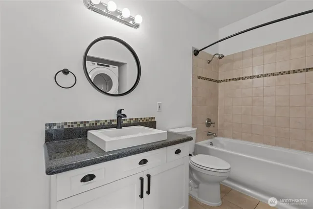 a bathroom with a granite countertop sink a toilet and a bathtub