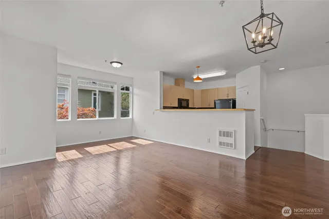 a view of a kitchen with a stove wooden cabinets and wooden floor
