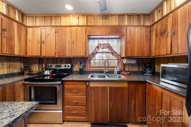 a kitchen with stainless steel appliances a stove a sink and a microwave
