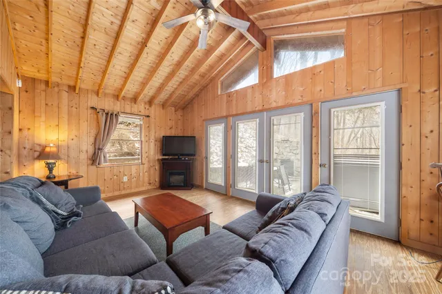a living room with furniture a flat screen tv and a large window