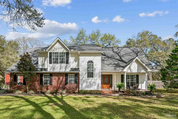 a front view of a house with a yard outdoor seating and garage