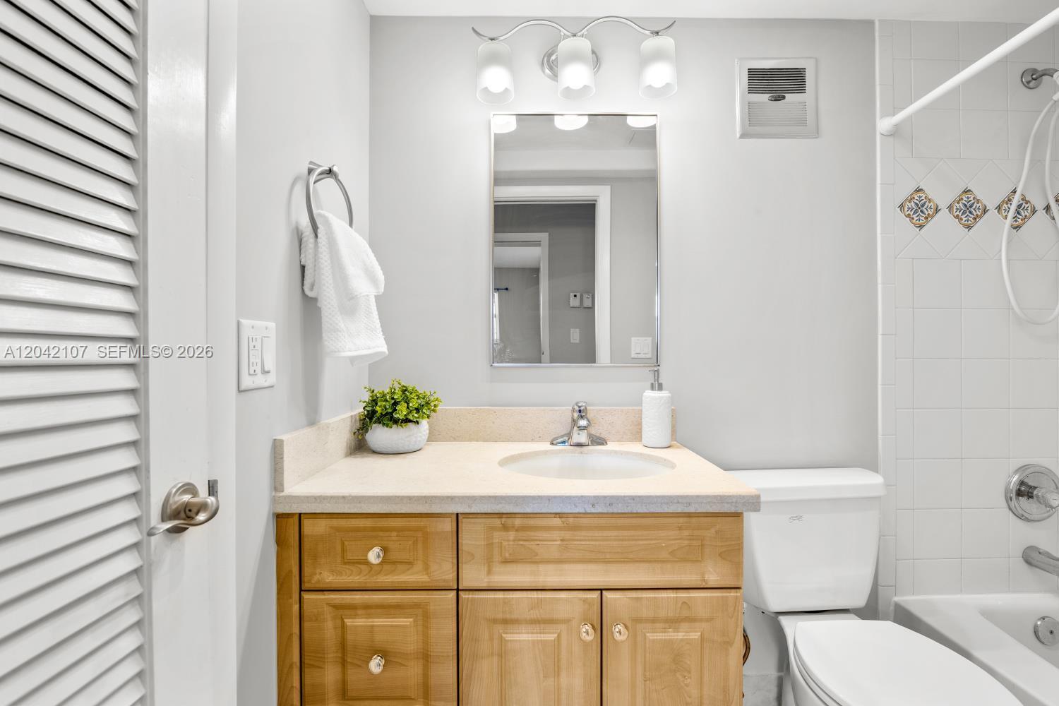 3213 Colony Club Road, Unit 3E Pompano Beach, FL 33062 - Photo 25 of 31 a bathroom with a sink and a mirror
