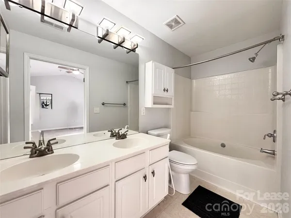 a bathroom with a double vanity sink toilet mirror and bathtub