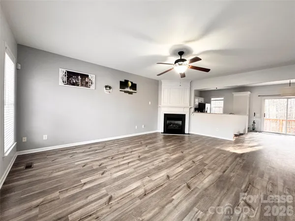 a view of an empty room with a kitchen and a window