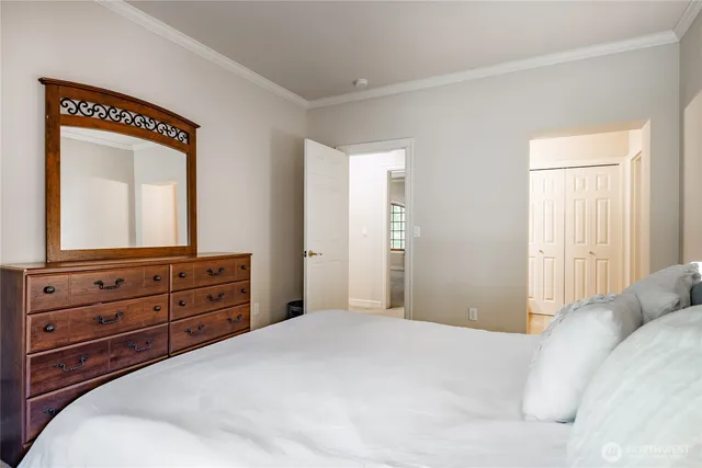 a bedroom with a bed and a mirror on dresser