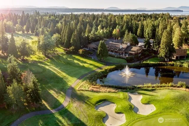 a view of a swimming pool with a bench and trees in the background