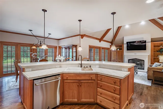 a kitchen with stainless steel appliances granite countertop a sink and a wooden floor