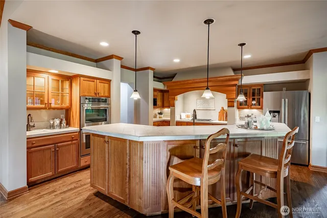 a kitchen with a table chairs stove and wooden floor