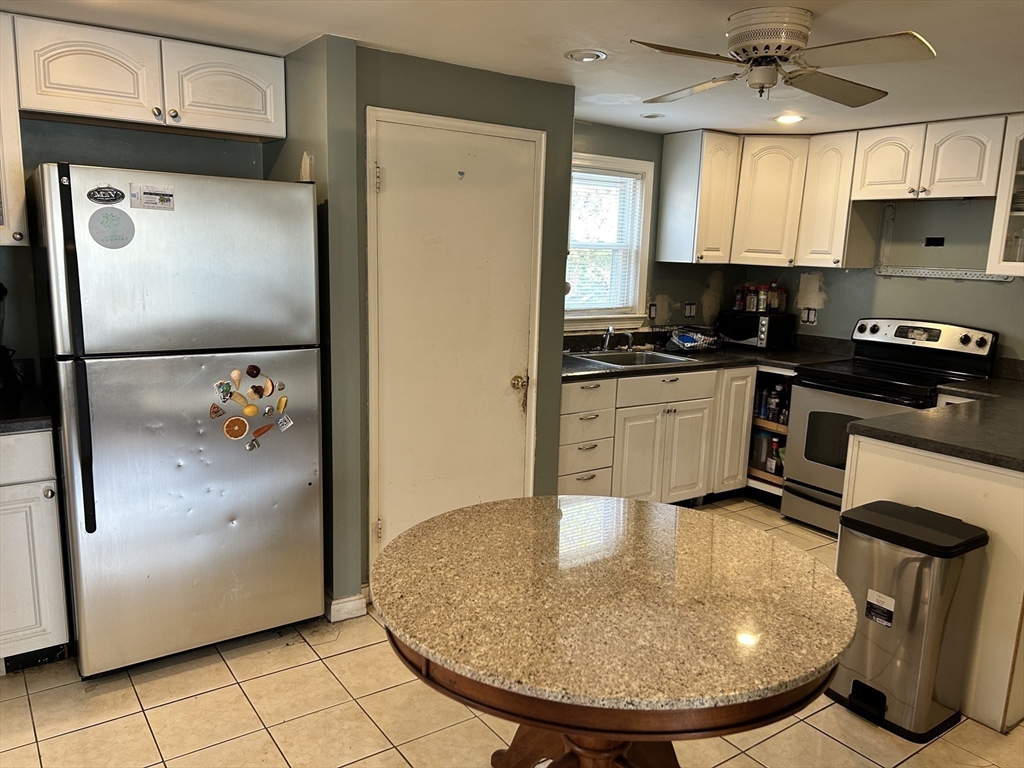 27 Evans Road Stoneham, MA 02180 - Photo 5 of 10 a kitchen with stainless steel appliances granite countertop a refrigerator a stove and a sink