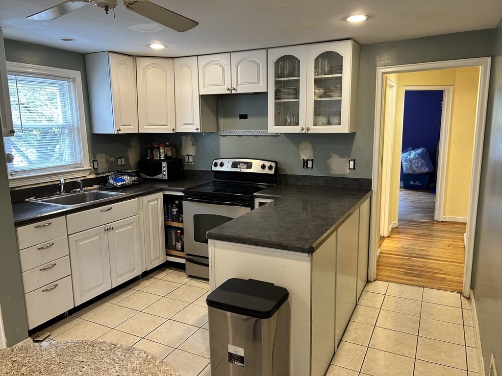 27 Evans Road Stoneham, MA 02180 - Photo 6 of 10 a kitchen with granite countertop a stove a sink and a cabinets