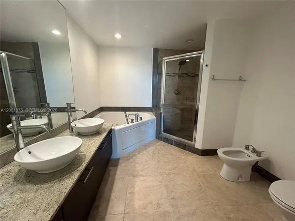 a bathroom with a tub sink toilet and mirror