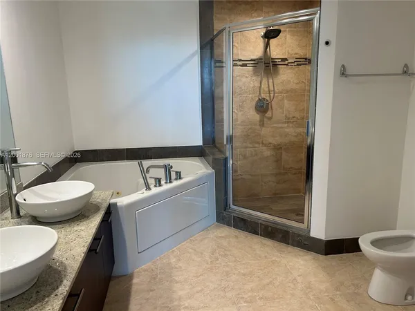 a bathroom with a granite countertop sink mirror toilet and bathtub