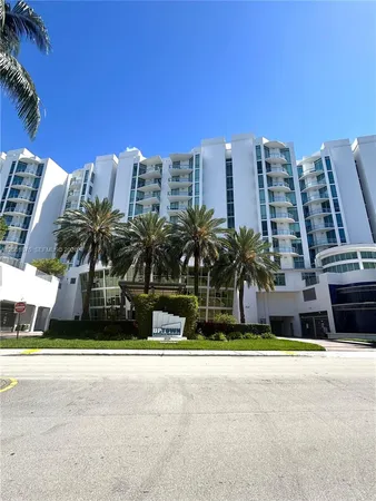 a front view of multi story residential apartment building with yard