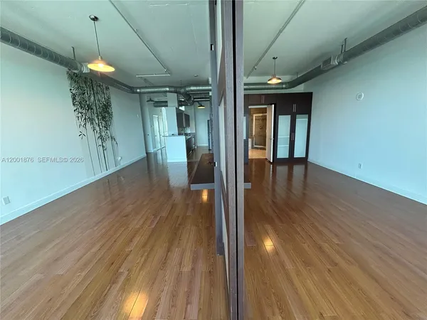 a view of a hallway with wooden floor