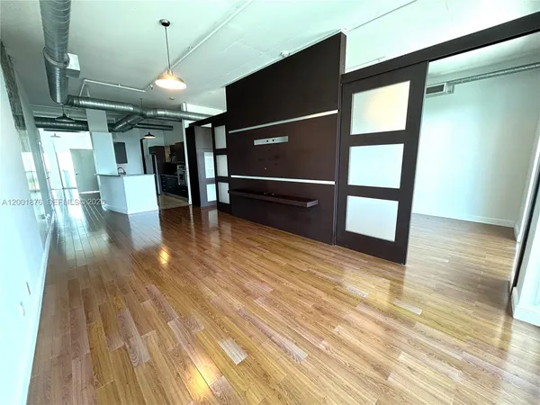 a view of empty room with wooden floor