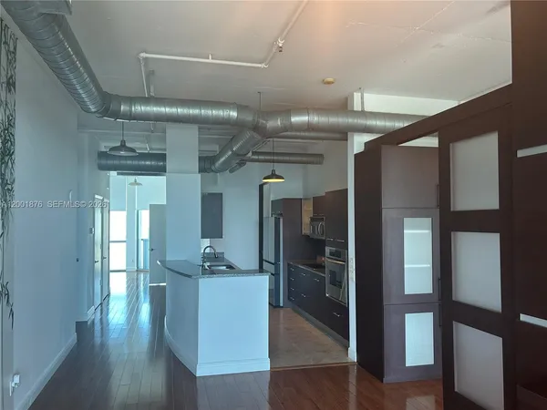 a view of a hallway with wooden floor and entryway
