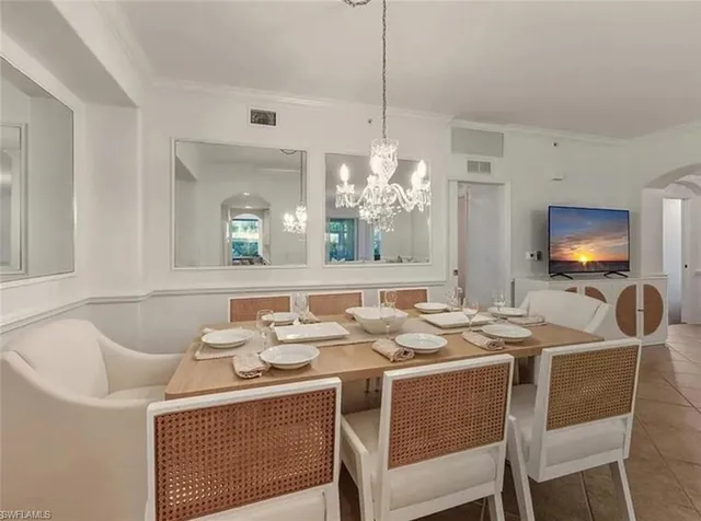 a dining room with furniture a chandelier and window