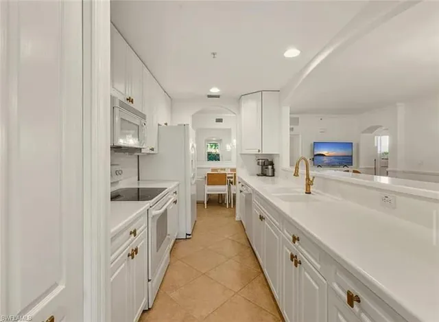 a large white kitchen with stainless steel appliances lots of counter top space