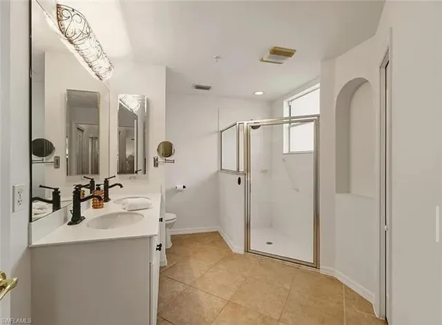 a bathroom with a double vanity sink mirror and shower
