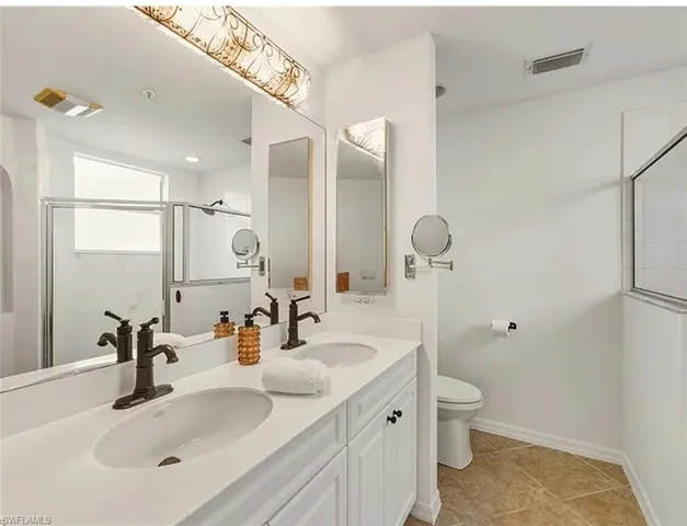 a bathroom with a sink double vanity and a toilet