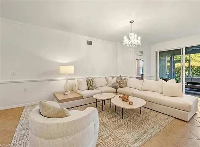 a living room with furniture and a chandelier