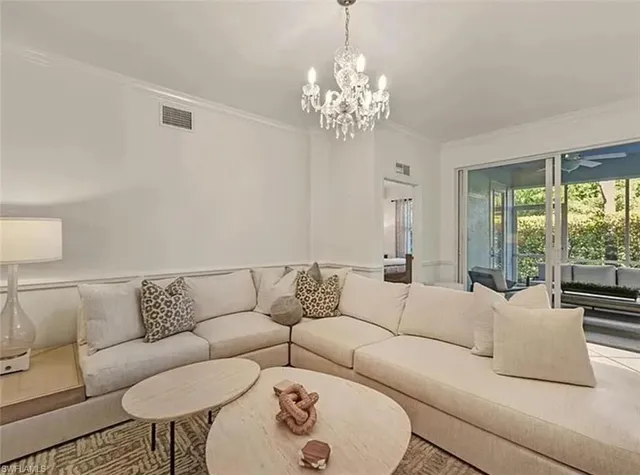 a living room with furniture and a chandelier