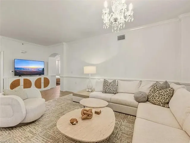 a living room with furniture and a chandelier