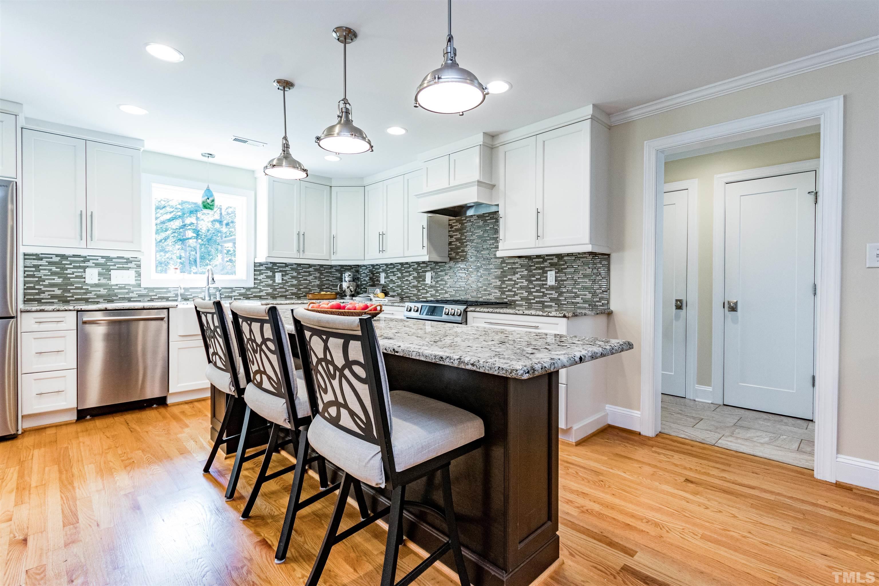 1509 Lutz Avenue Raleigh, NC 27607 - Photo 11 of 30 a kitchen with granite countertop a table chairs stove a refrigerator and cabinets