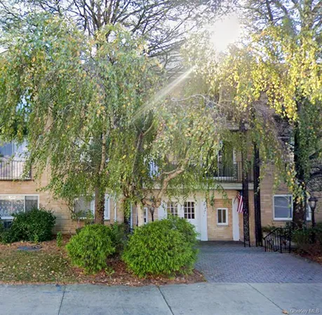 a front view of a house with a yard and tree