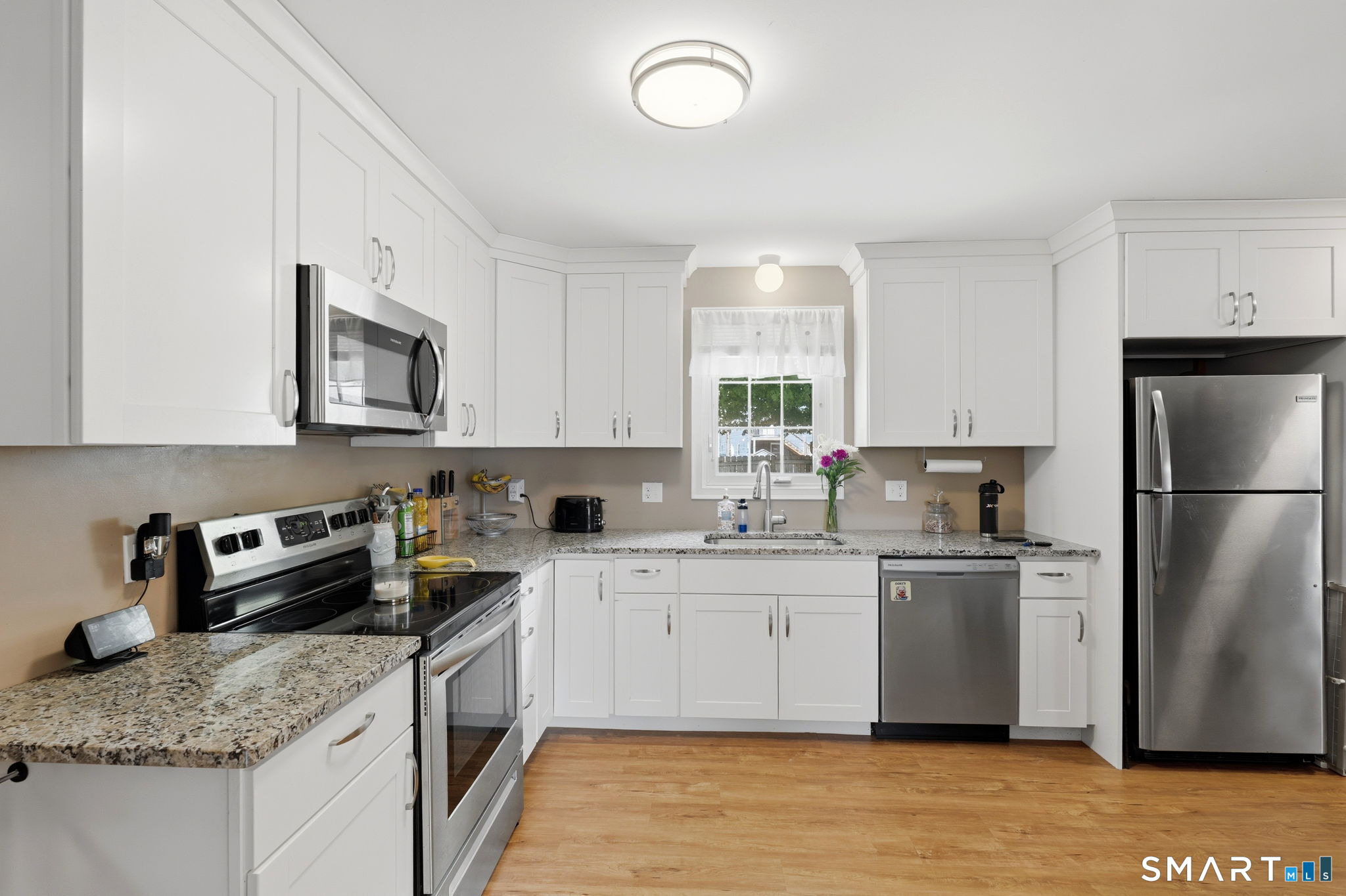 71 Smith Street Putnam, CT 06260 - Photo 14 of 25 a kitchen with stainless steel appliances granite countertop a sink stove microwave and refrigerator
