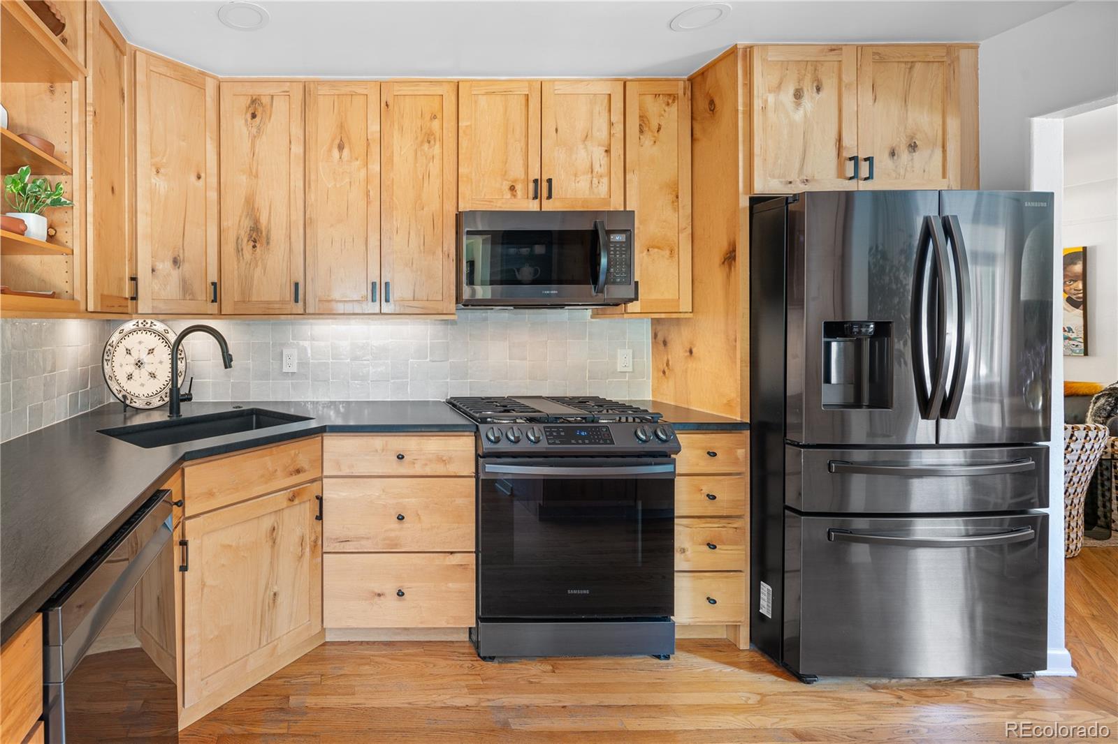 4225 Balsam Street Wheat Ridge, CO 80033 - Photo 11 of 33 a kitchen with stainless steel appliances granite countertop a refrigerator stove and sink