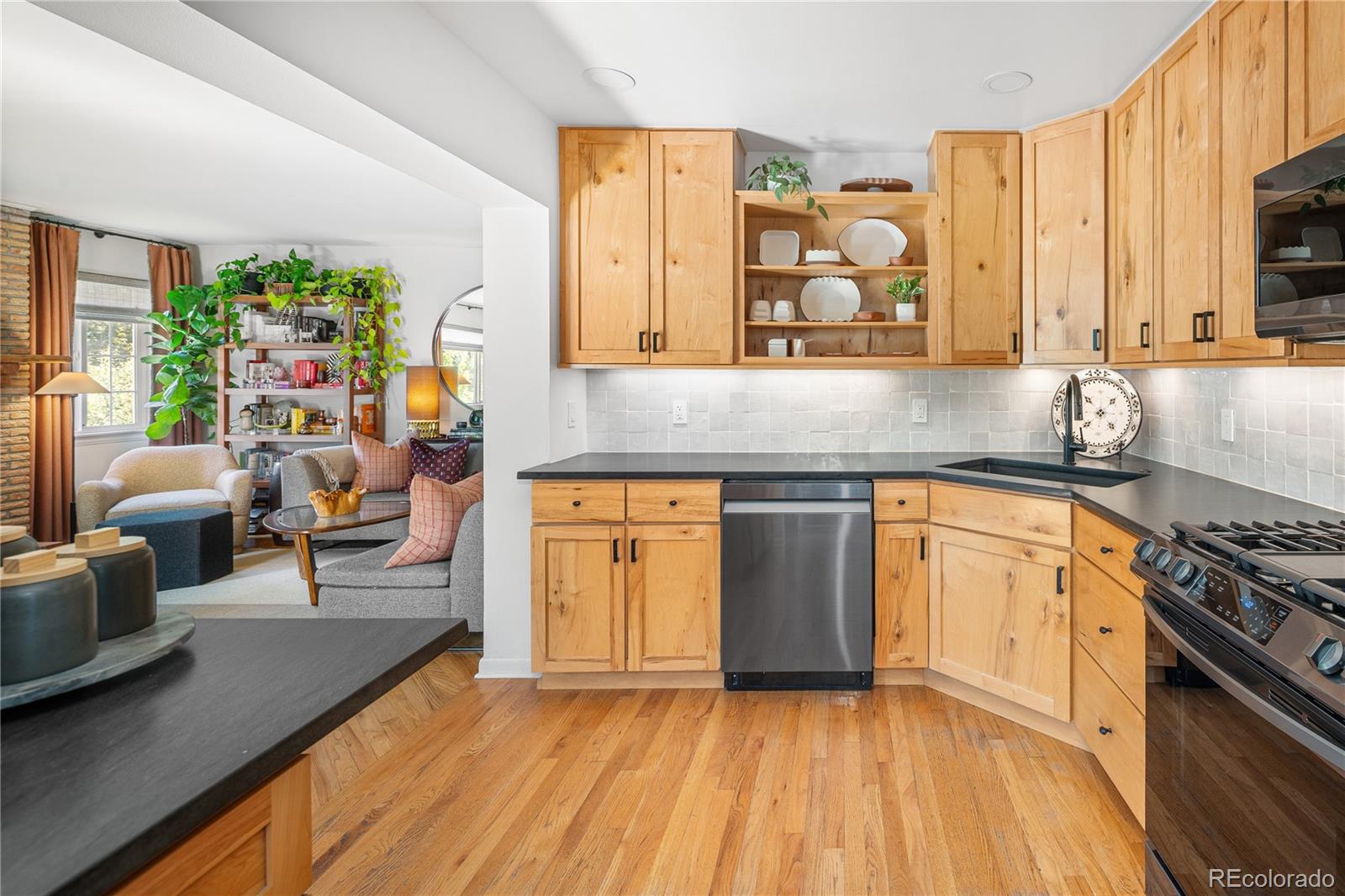 4225 Balsam Street Wheat Ridge, CO 80033 - Photo 12 of 33 a kitchen with stainless steel appliances granite countertop a stove a sink and a refrigerator