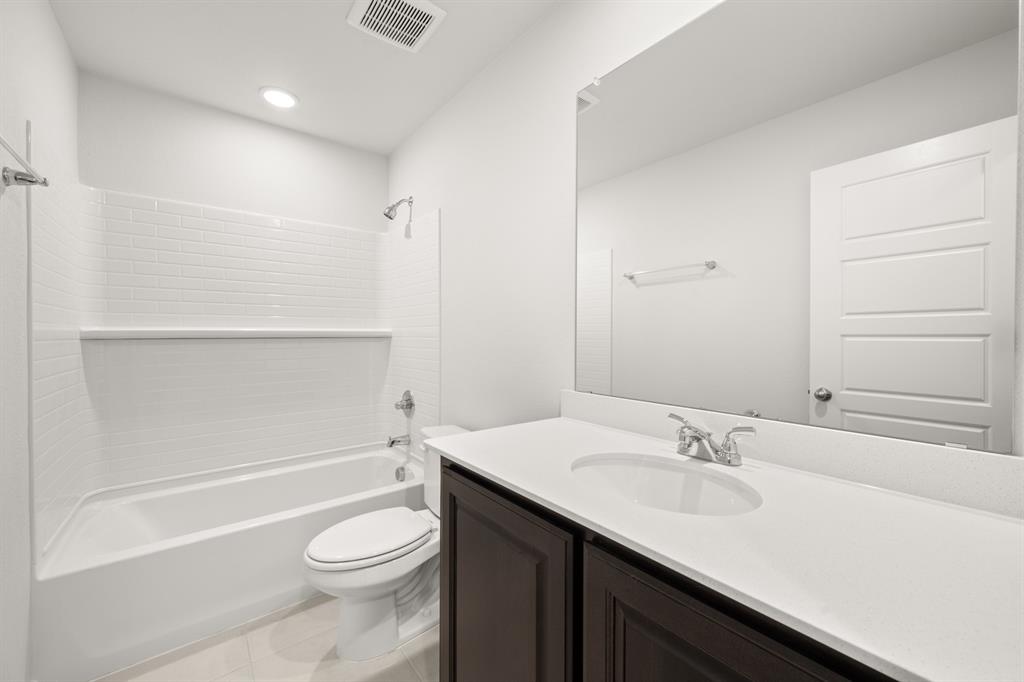 1908 Seminole Drive Cleburne, TX 76033 - Photo 17 of 27 a bathroom with a sink a toilet and shower