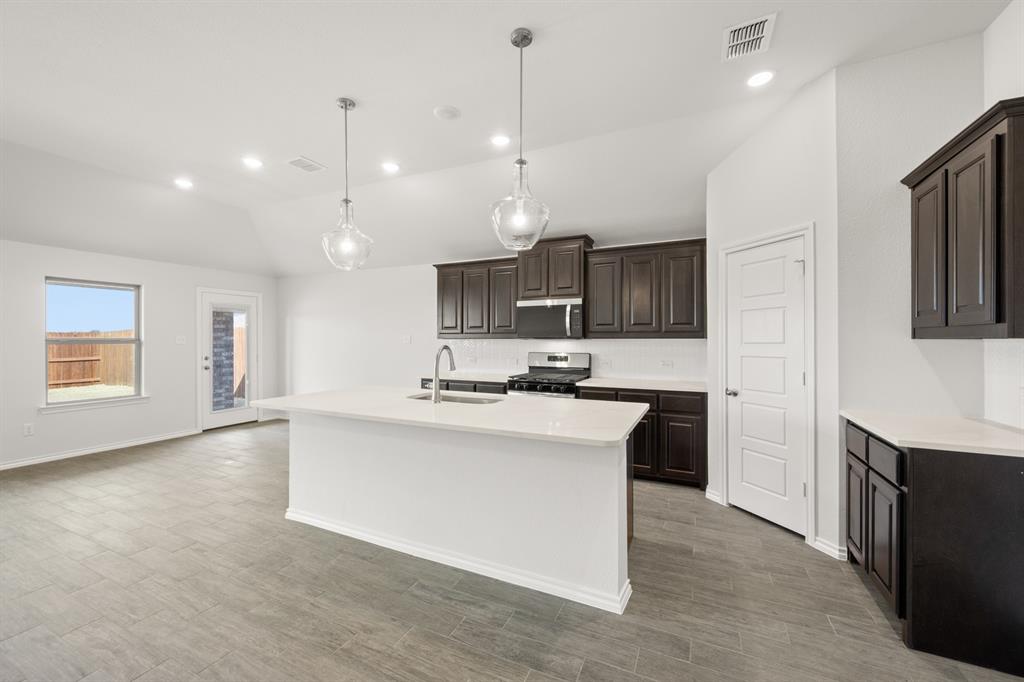 1908 Seminole Drive Cleburne, TX 76033 - Photo 5 of 27 a large kitchen with kitchen island a sink stainless steel appliances and cabinets