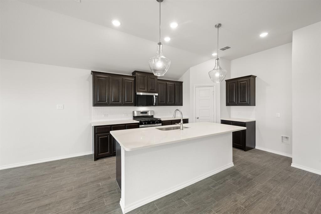 1908 Seminole Drive Cleburne, TX 76033 - Photo 6 of 27 a large kitchen with kitchen island a sink stainless steel appliances and cabinets