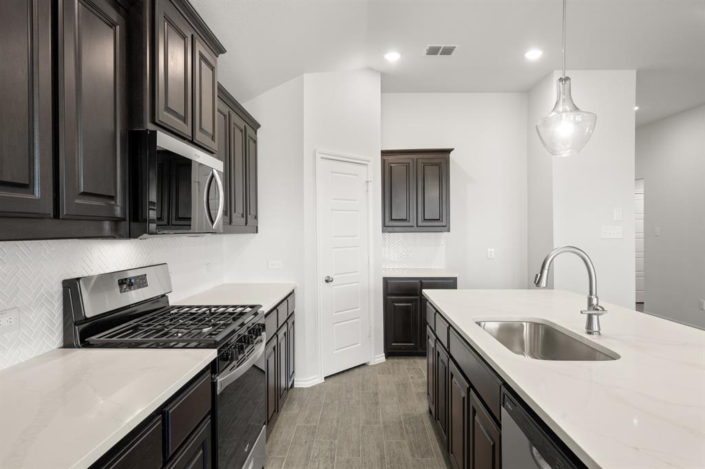 1908 Seminole Drive Cleburne, TX 76033 - Photo 7 of 27 a kitchen with stainless steel appliances granite countertop a sink stove and refrigerator