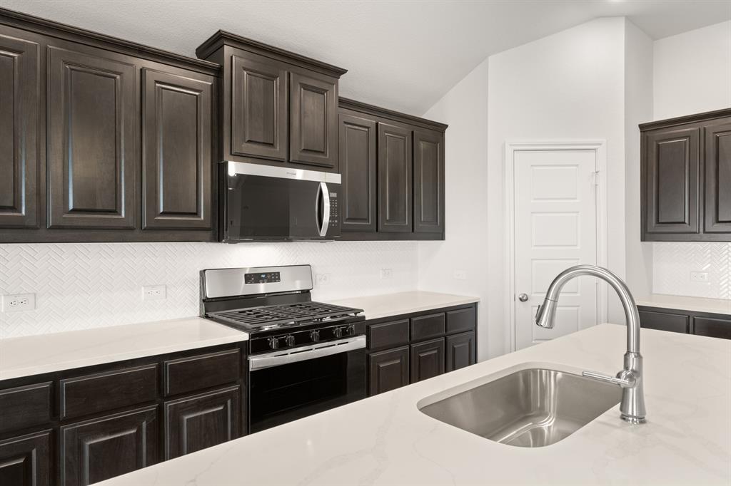 1908 Seminole Drive Cleburne, TX 76033 - Photo 9 of 27 a kitchen with granite countertop a sink cabinets and stainless steel appliances