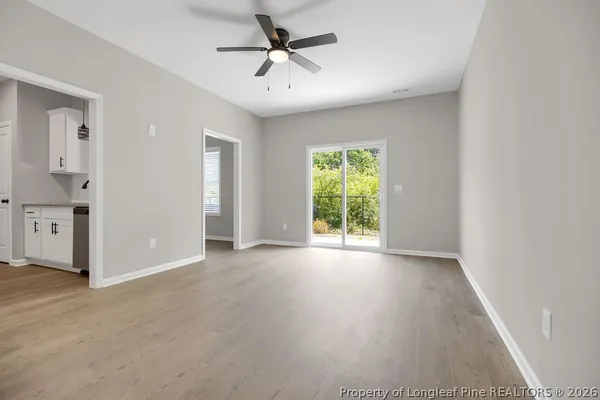 an empty room with windows and fan