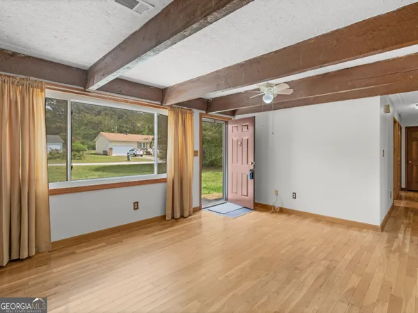 a view of a room with wooden floor and windows